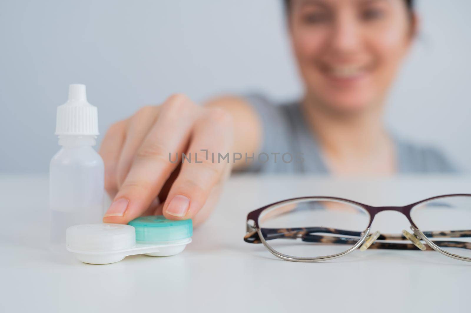 Caucasian woman prefers contact lenses to glasses. by mrwed54