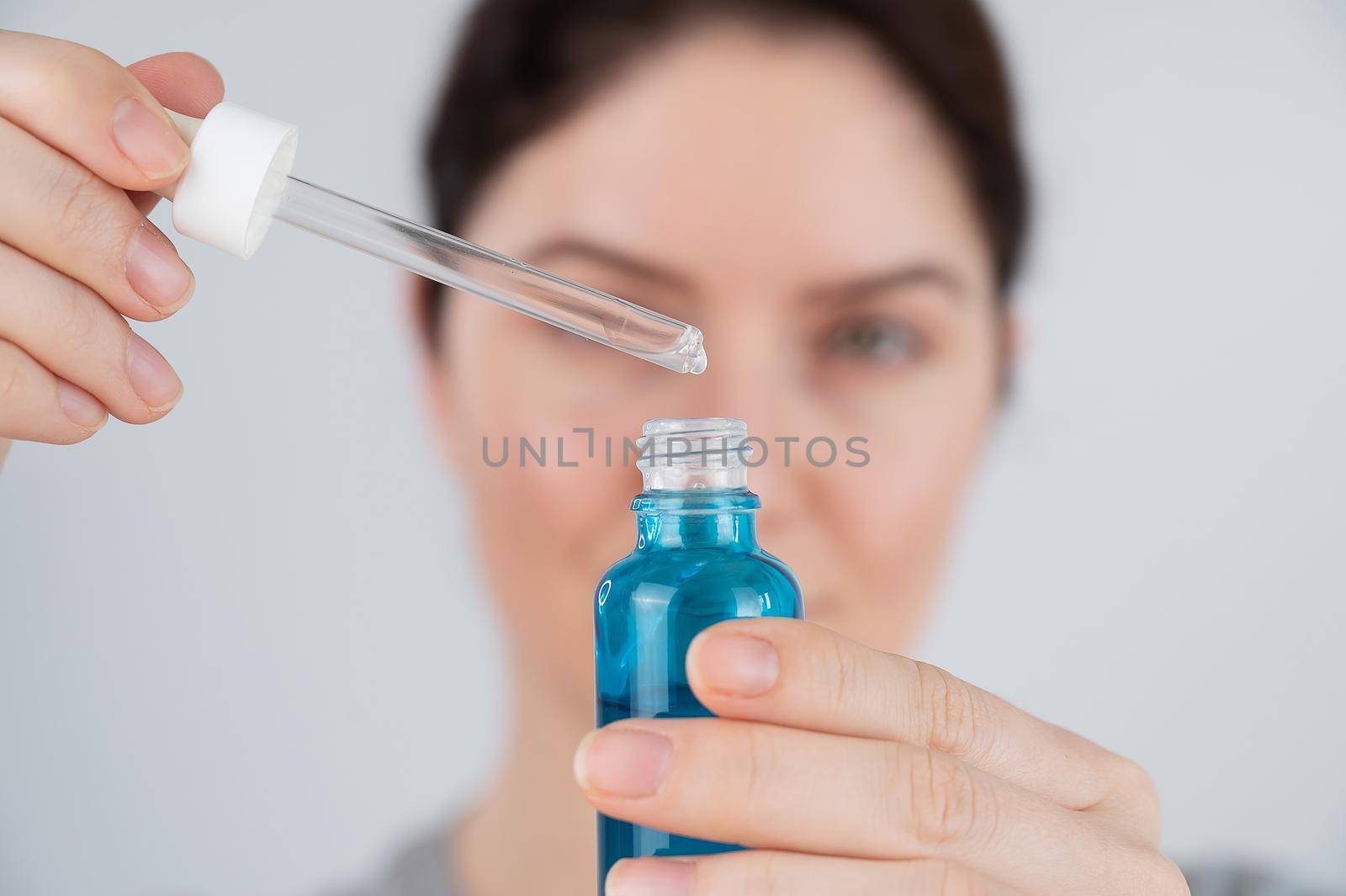 Caucasian woman uses blue anti-wrinkle face serum