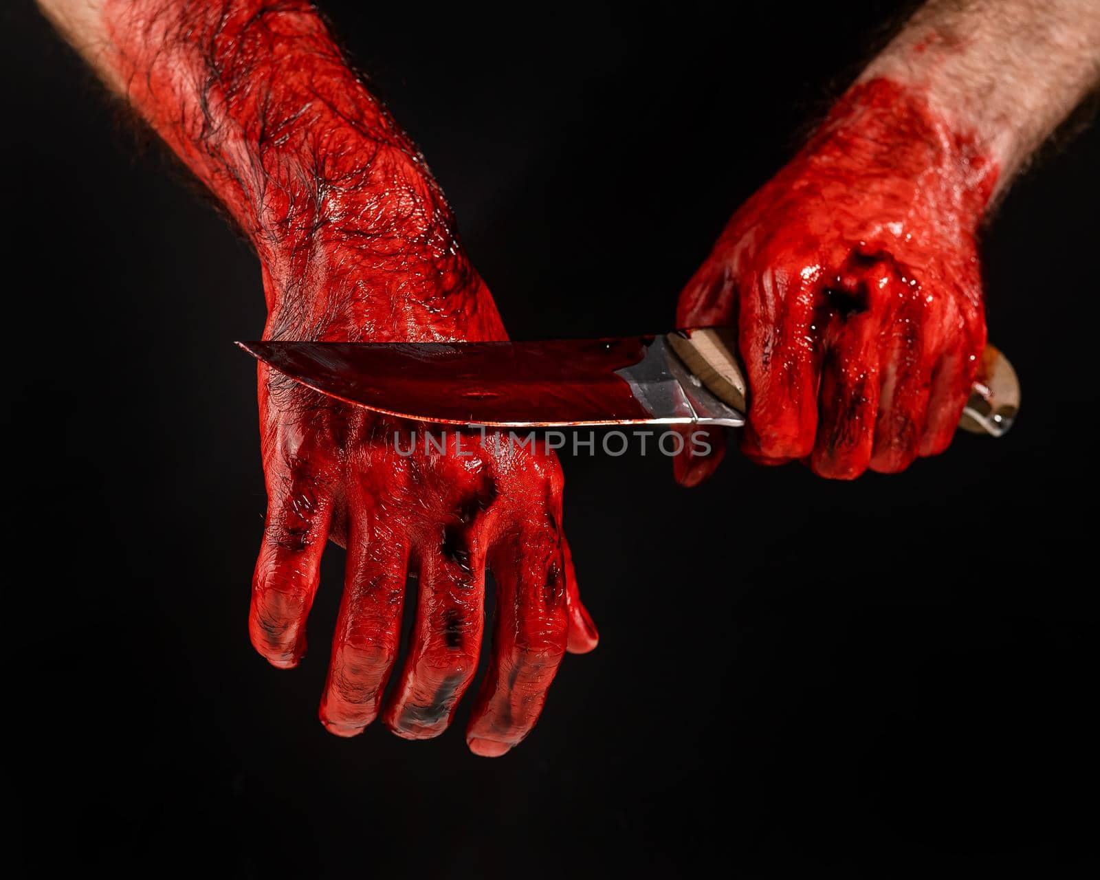 Man holding knife with bloody hand on black background. by mrwed54