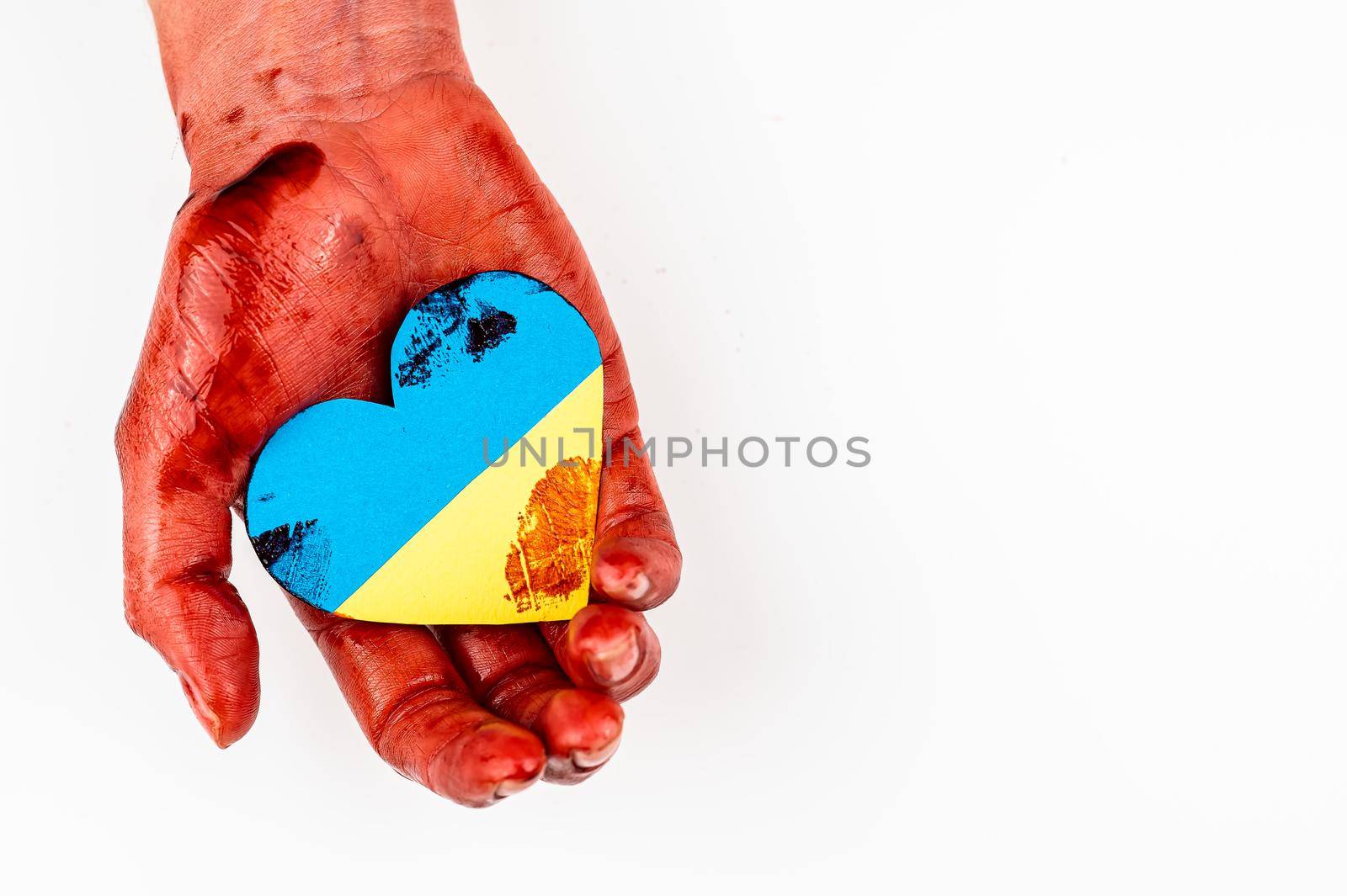 Woman with hands covered in blood holding a heart with the flag of ukraine on a white background. Copy spae