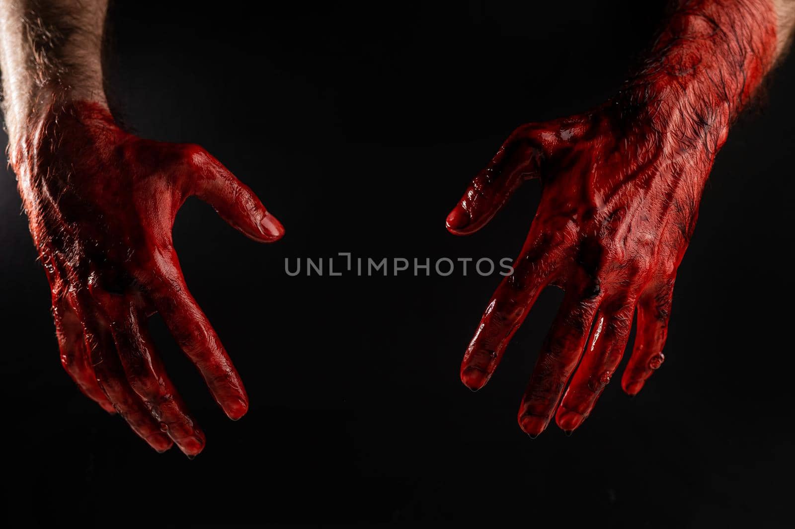 Male bloody hands on a black background