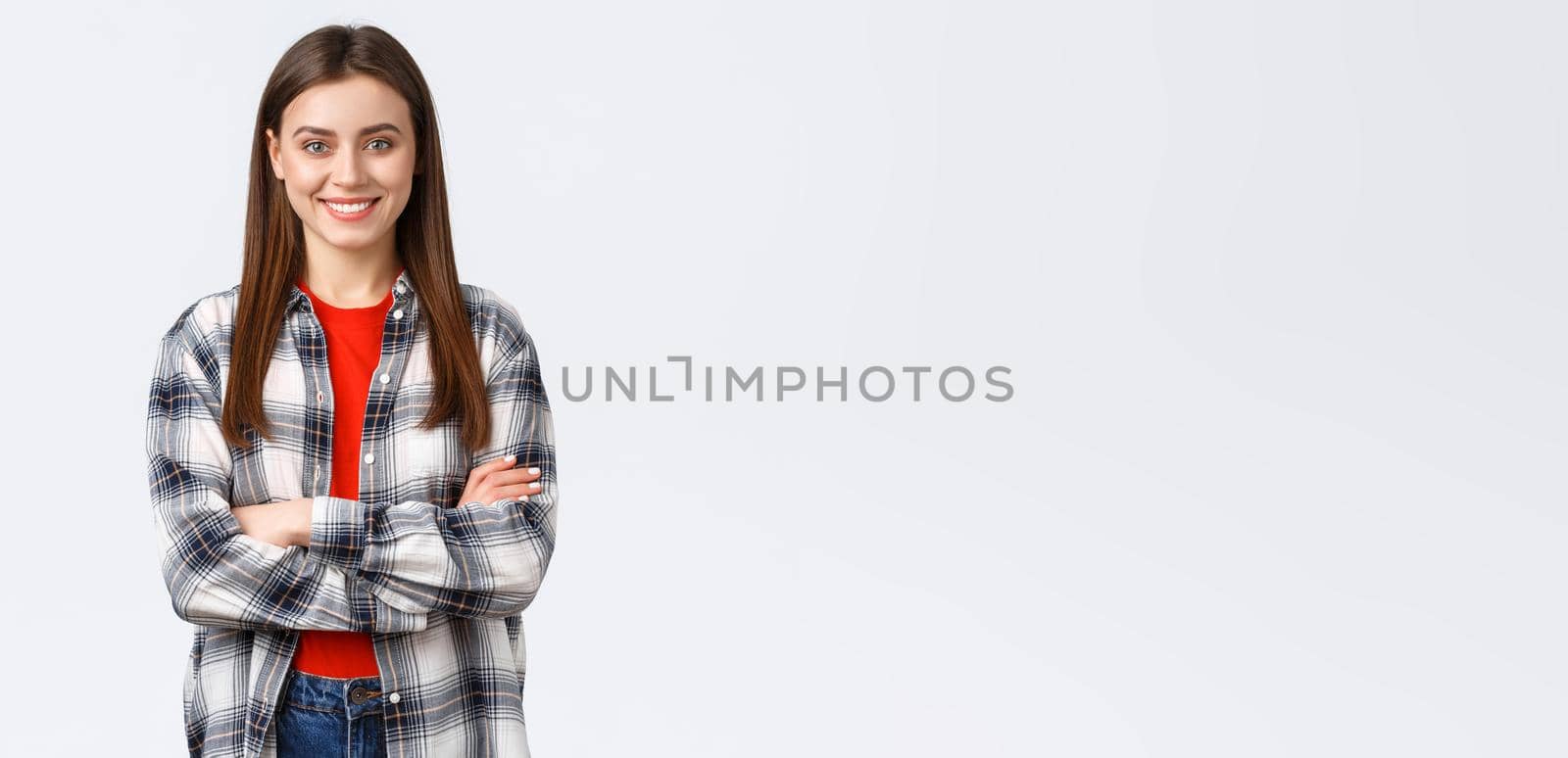 Lifestyle, different emotions, leisure activities concept. Cheerful young caucasian girl, female student in checked casual shirt, cross arms chest and demiling pleased, standing white background by Benzoix