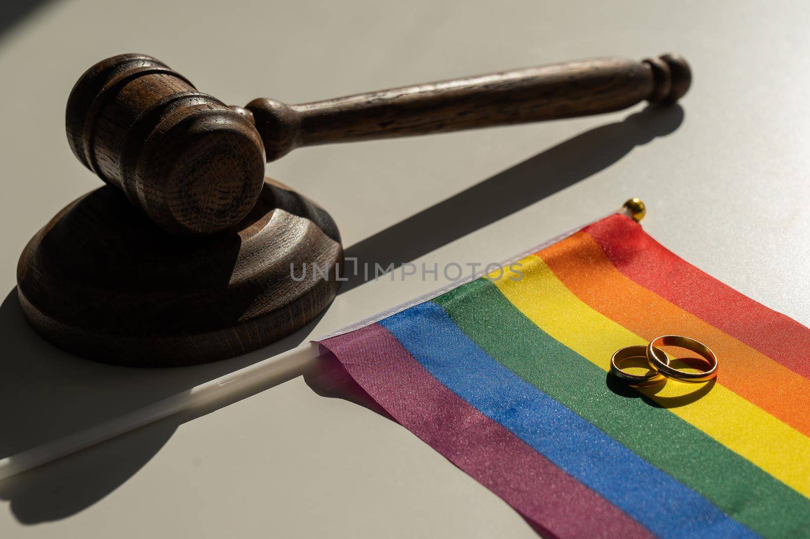 Legalization of same-sex marriages. Rainbow flag wedding rings and judge's gavel