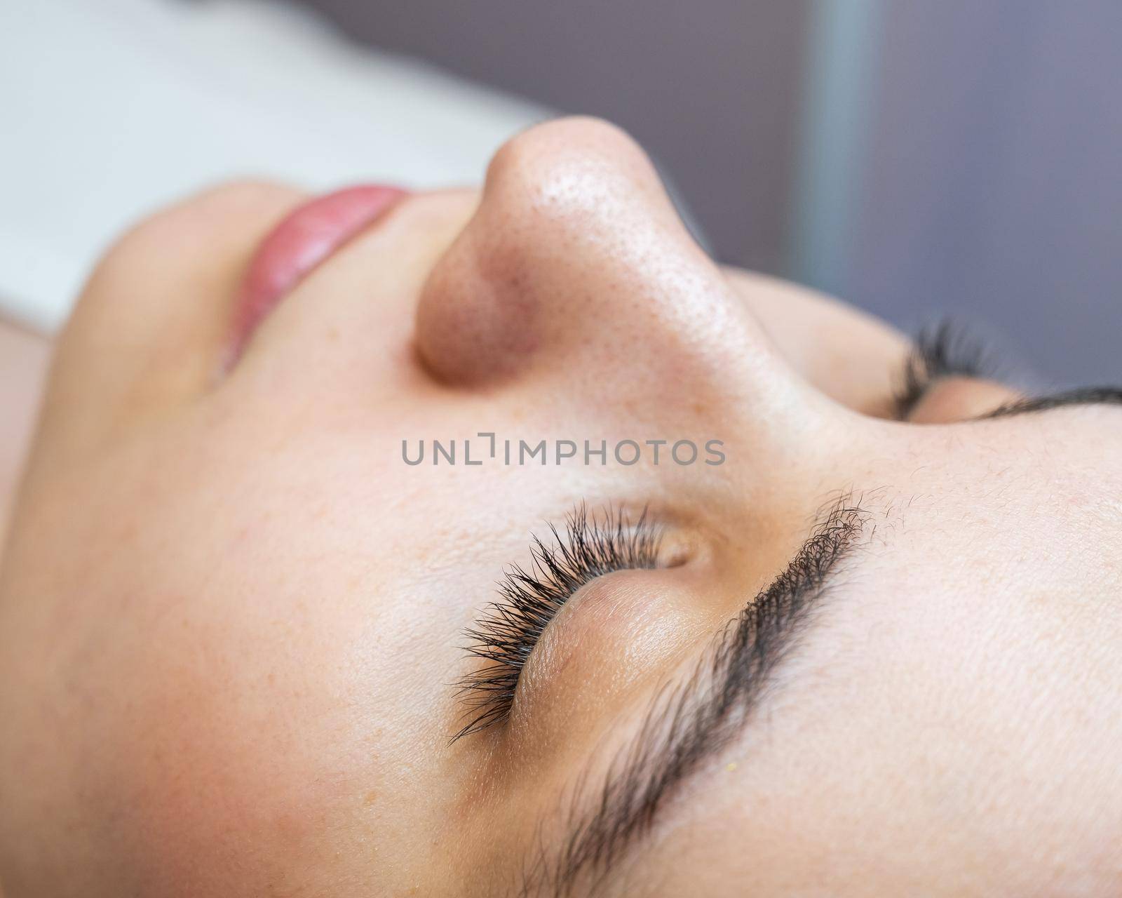 Close-up portrait of a young caucasian woman before eyelash lamination procedure