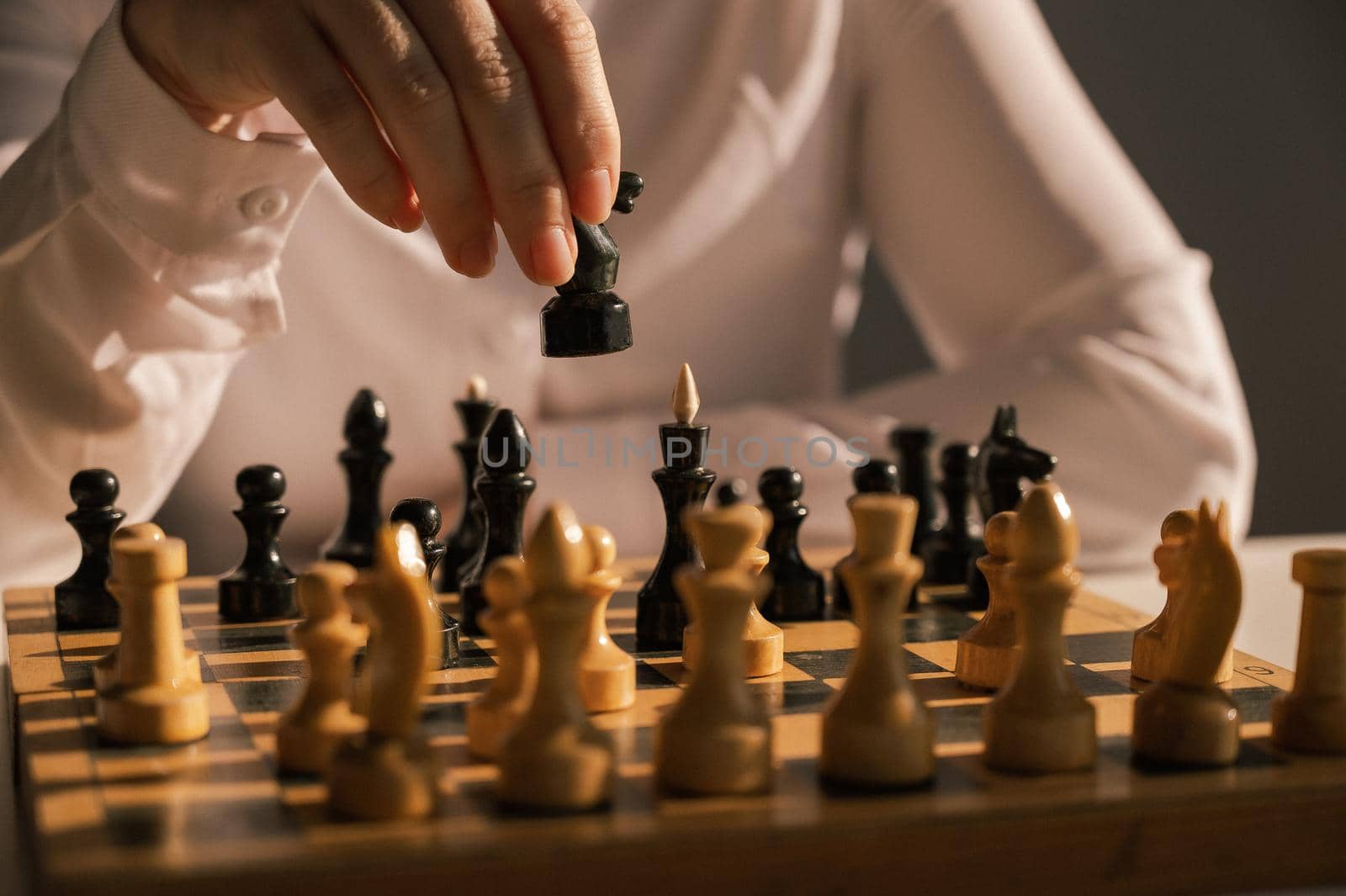 Faceless caucasian woman in white shirt playing chess