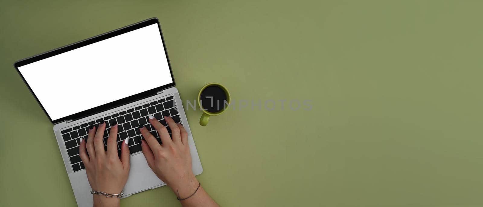 Creative woman using computer laptop on green background with copy space.