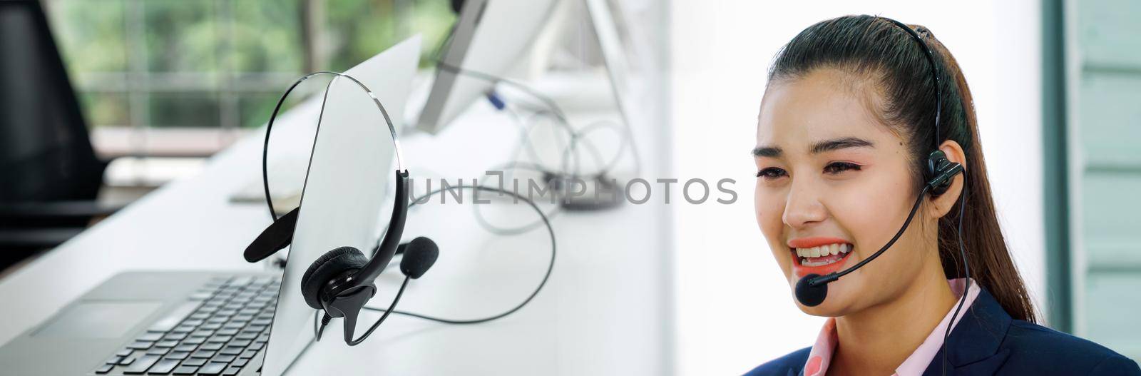 Business people wearing headset working in office in widen view to support remote customer or colleague. Call center, telemarketing, customer support agent provide service on telephone video call.