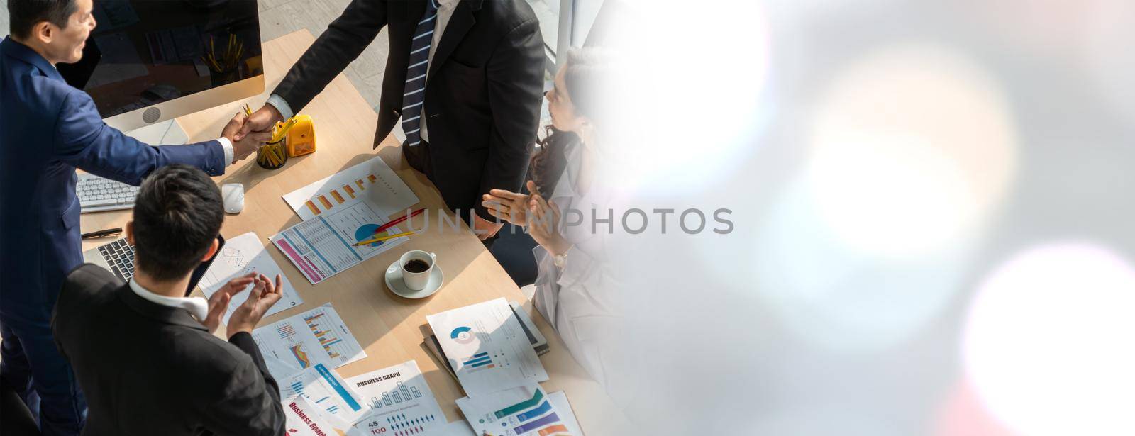 Group business people handshake at meeting table in widen view in office together with confident shot from top view . Young businessman and businesswoman workers express agreement of investment deal.