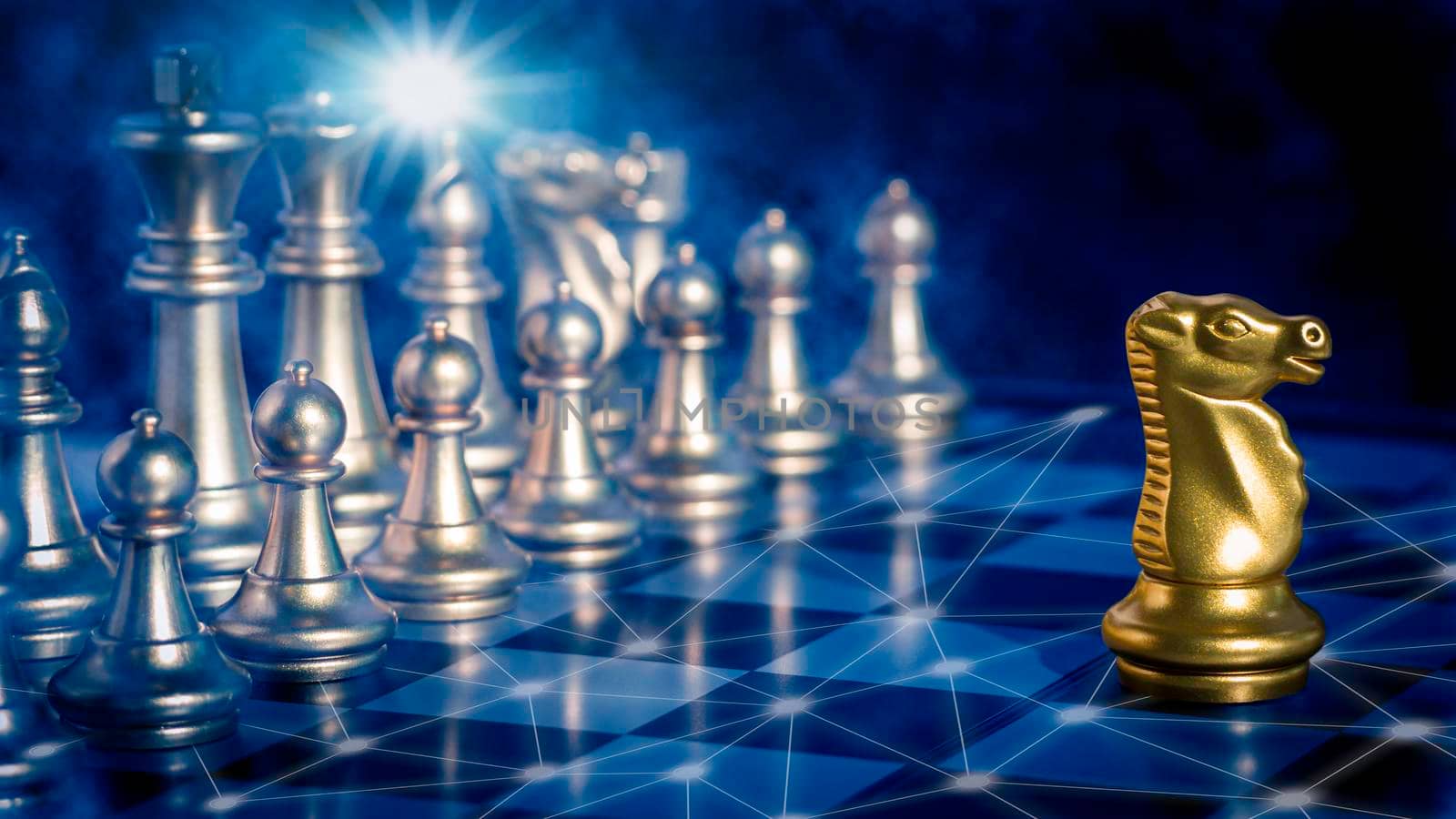 Golden knight chess is leadership in front off silver chess pieces on chess board with network and communication 
flare light to fighting with teamwork to victory, business strategy concept for success.