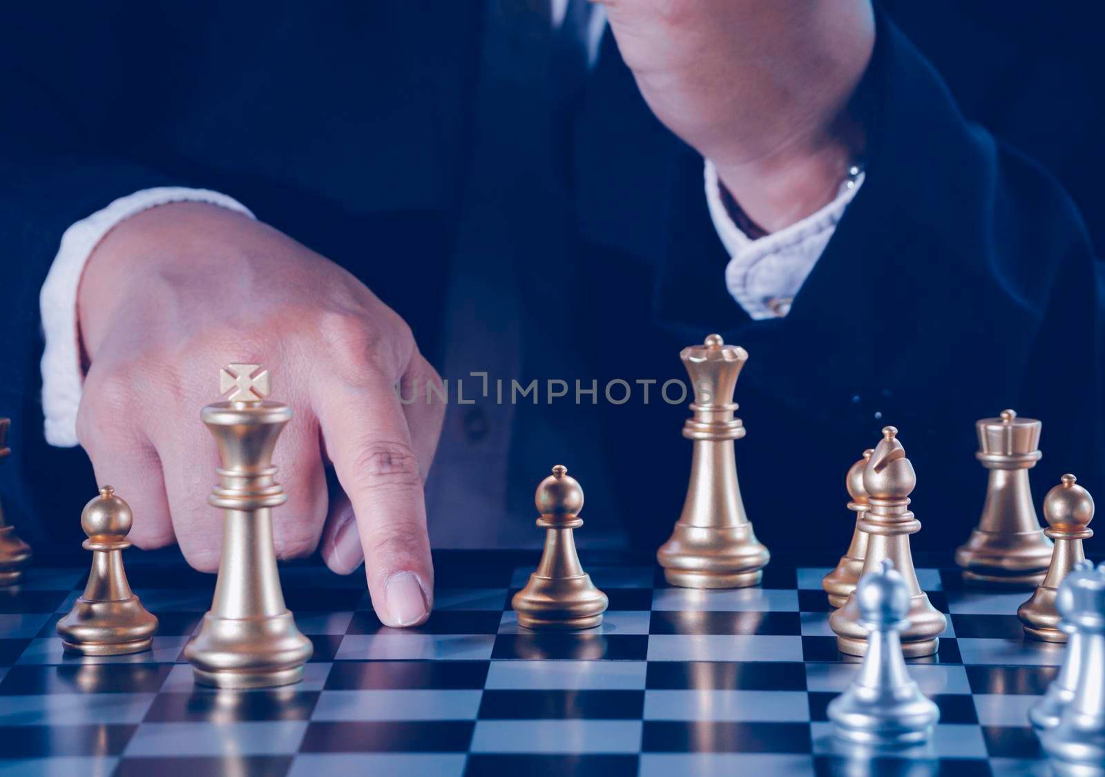Hand of businessman holding gold king chess on stock market or forex trading graph chart with cityscape image economy trend for digital financial investment.Management or leadership strategy concept.