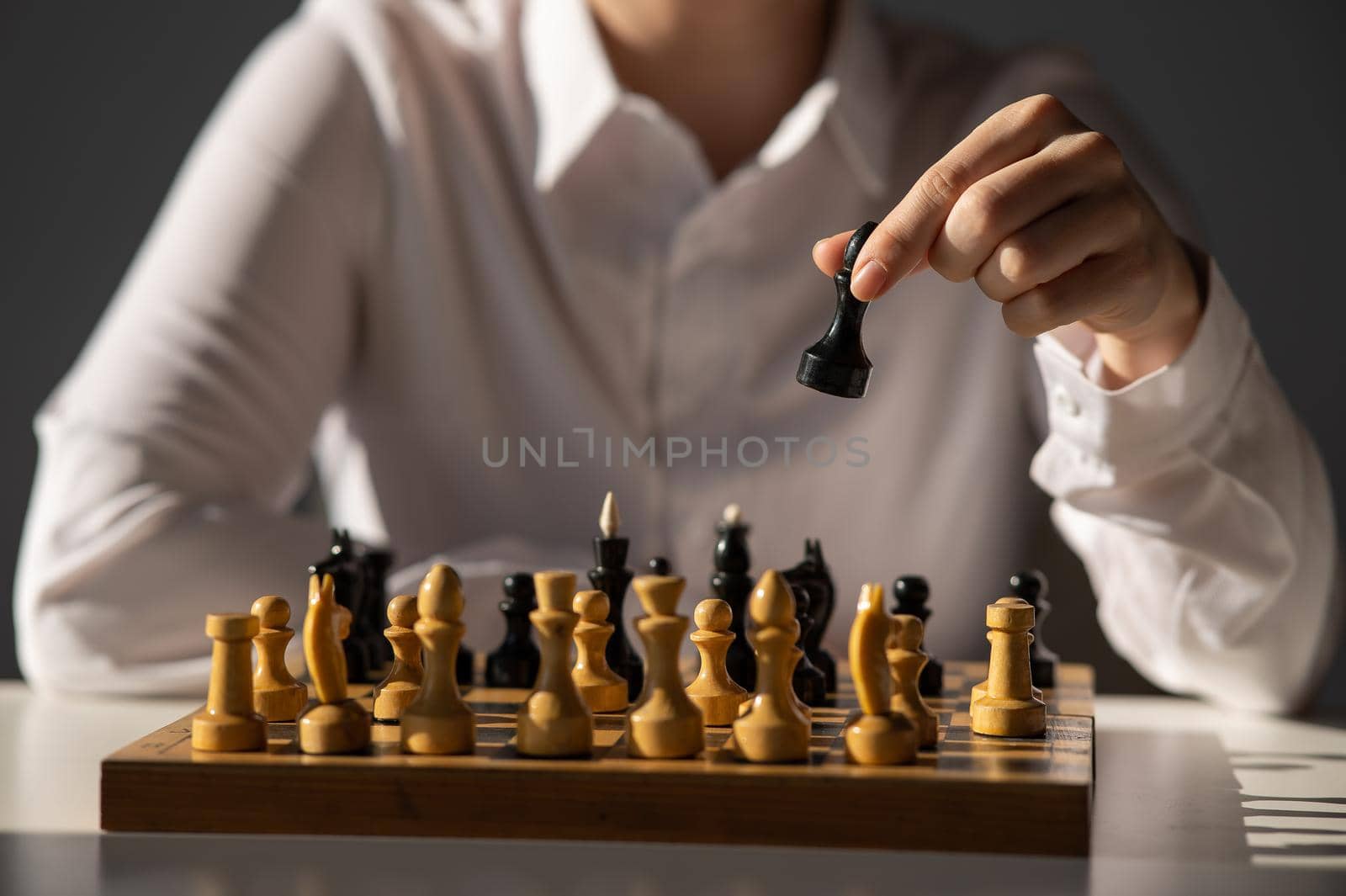 Faceless caucasian woman in white shirt playing chess. by mrwed54