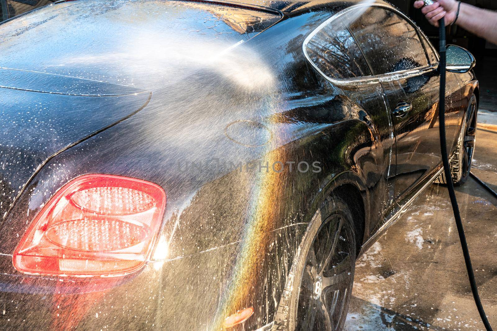 auto detailer washing luxury high end car by digidreamgrafix