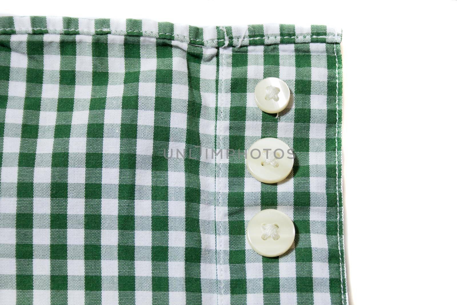 Three white spare buttons on green men's shirt