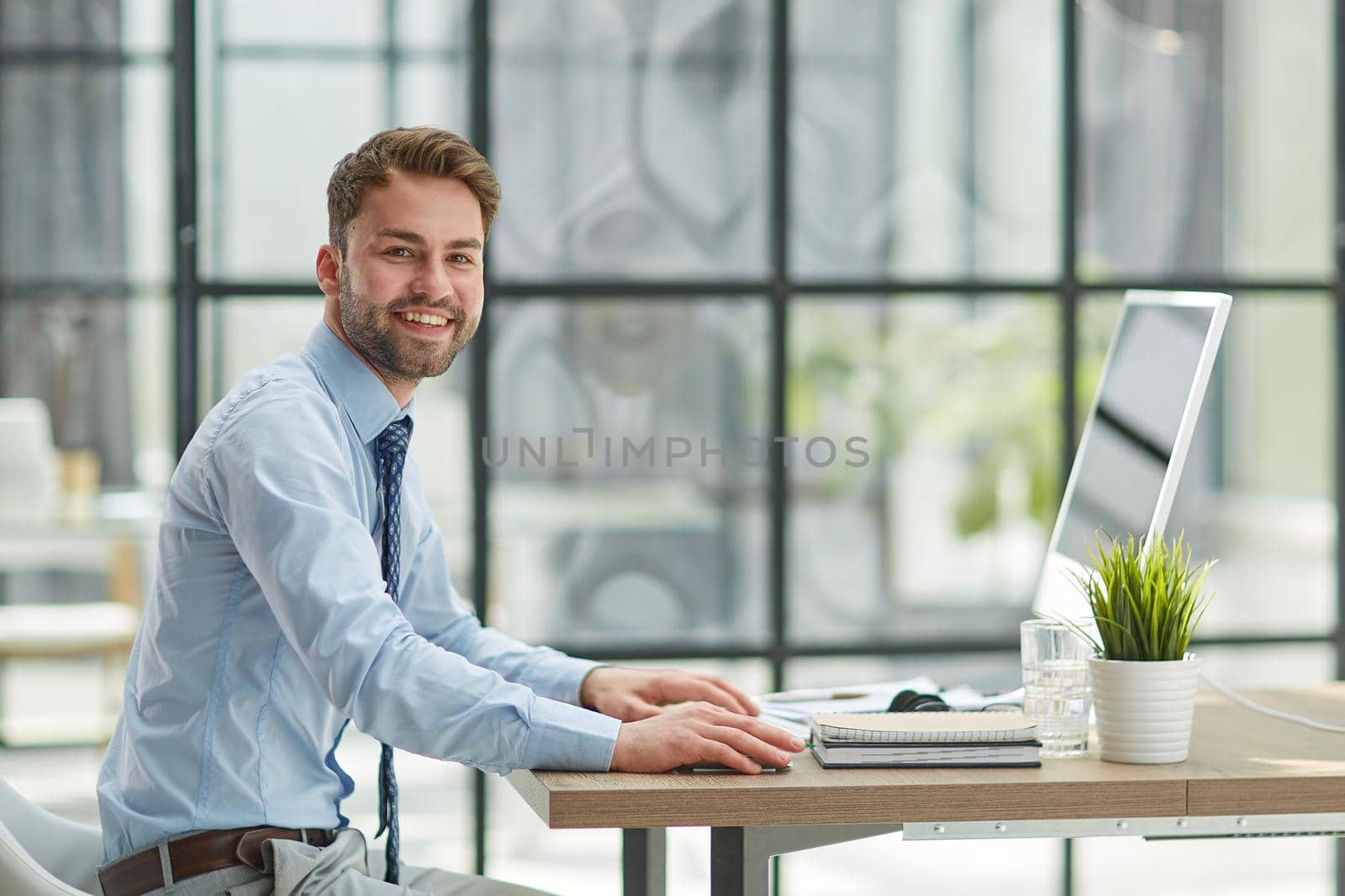 Young businessman working at modern glass office by Prosto