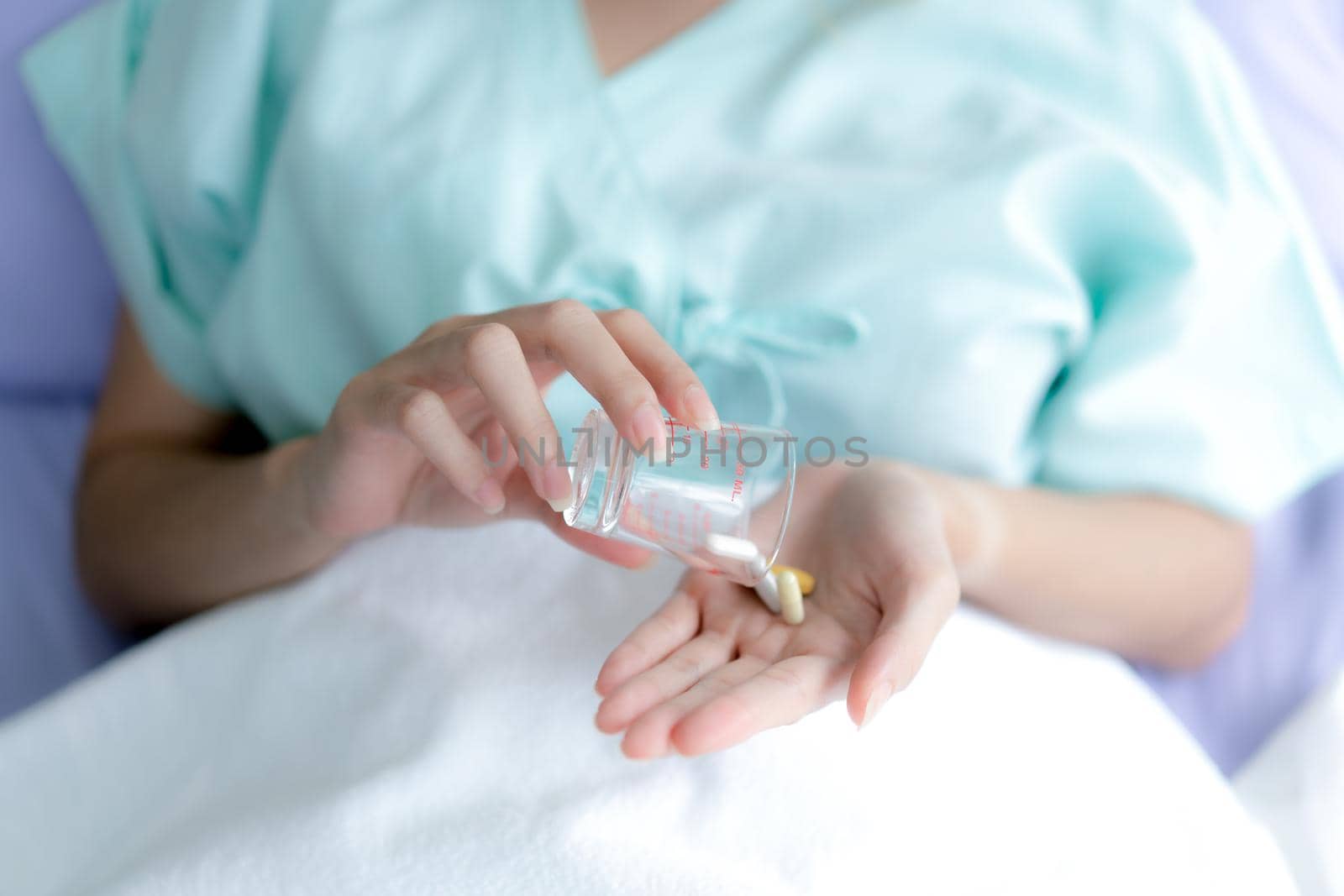 Hand taking pills to treat sickness at the hospital.