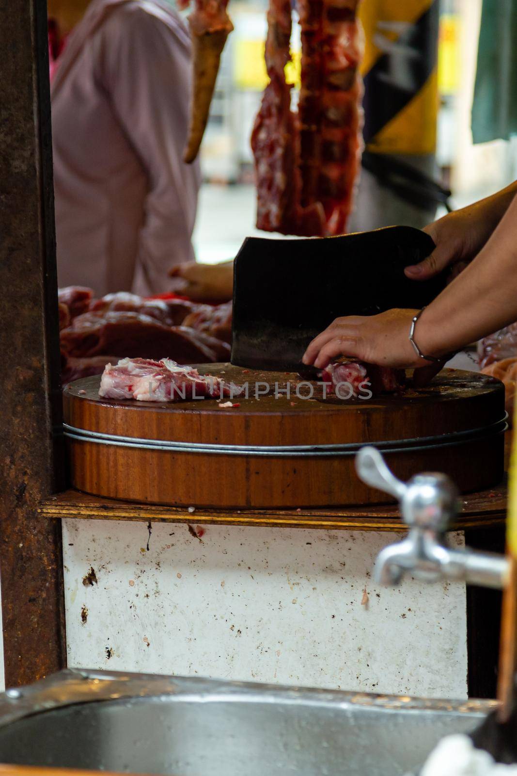 Fresh meat hanging at meat vendor in a Taipei market by imagesbykenny