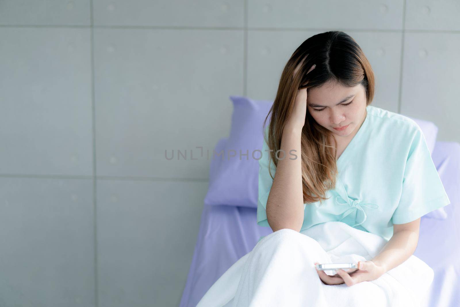 Female patient being treated in hospital, stressed on bed in the hospital room