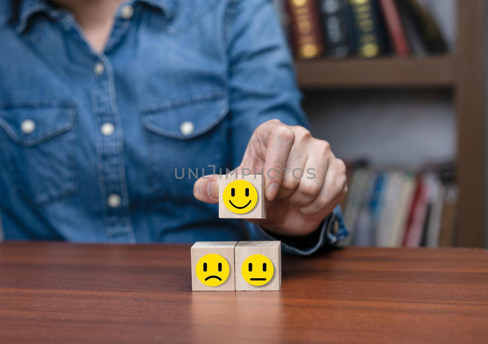 Human hands holding wooden cubes with smile emotion.  Concept emotion for business survey