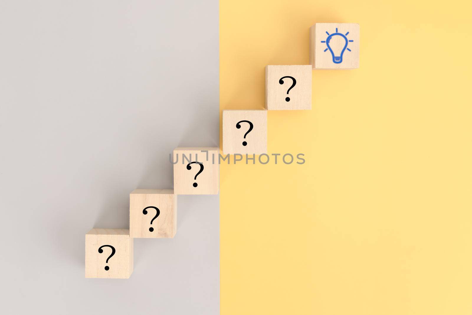 Creativity and innovation, question symbol on wooden cube blocks with light bulb icon for idea concept