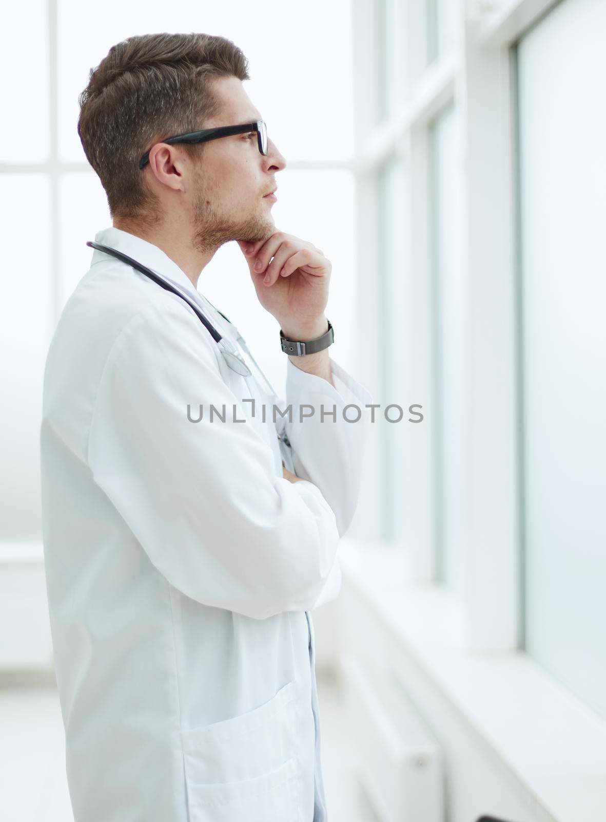 handsome young doctor portrait in medical office by Prosto