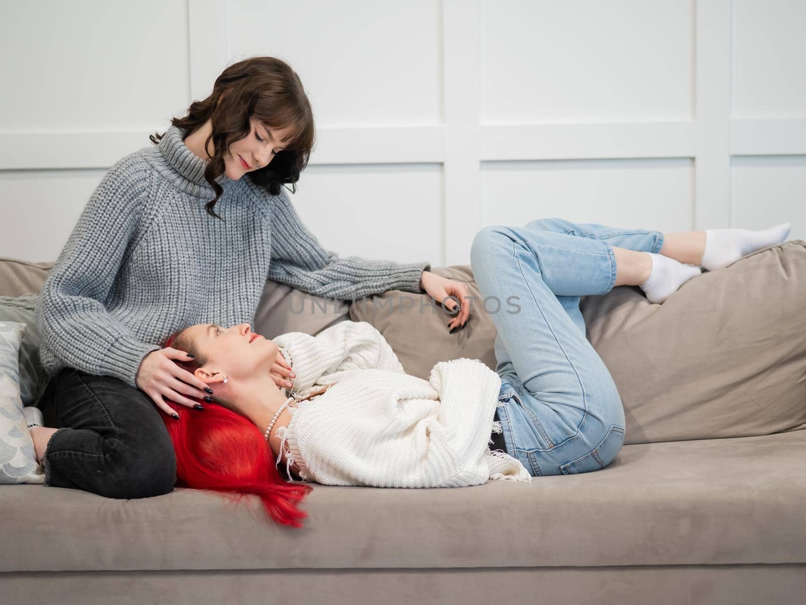 Young girls hugging while lying on the couch. Unisexual love