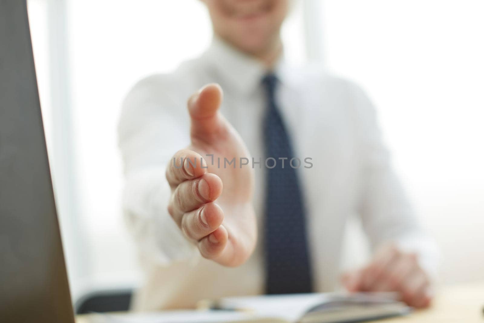 Businessman extending hand to shake at office by Prosto