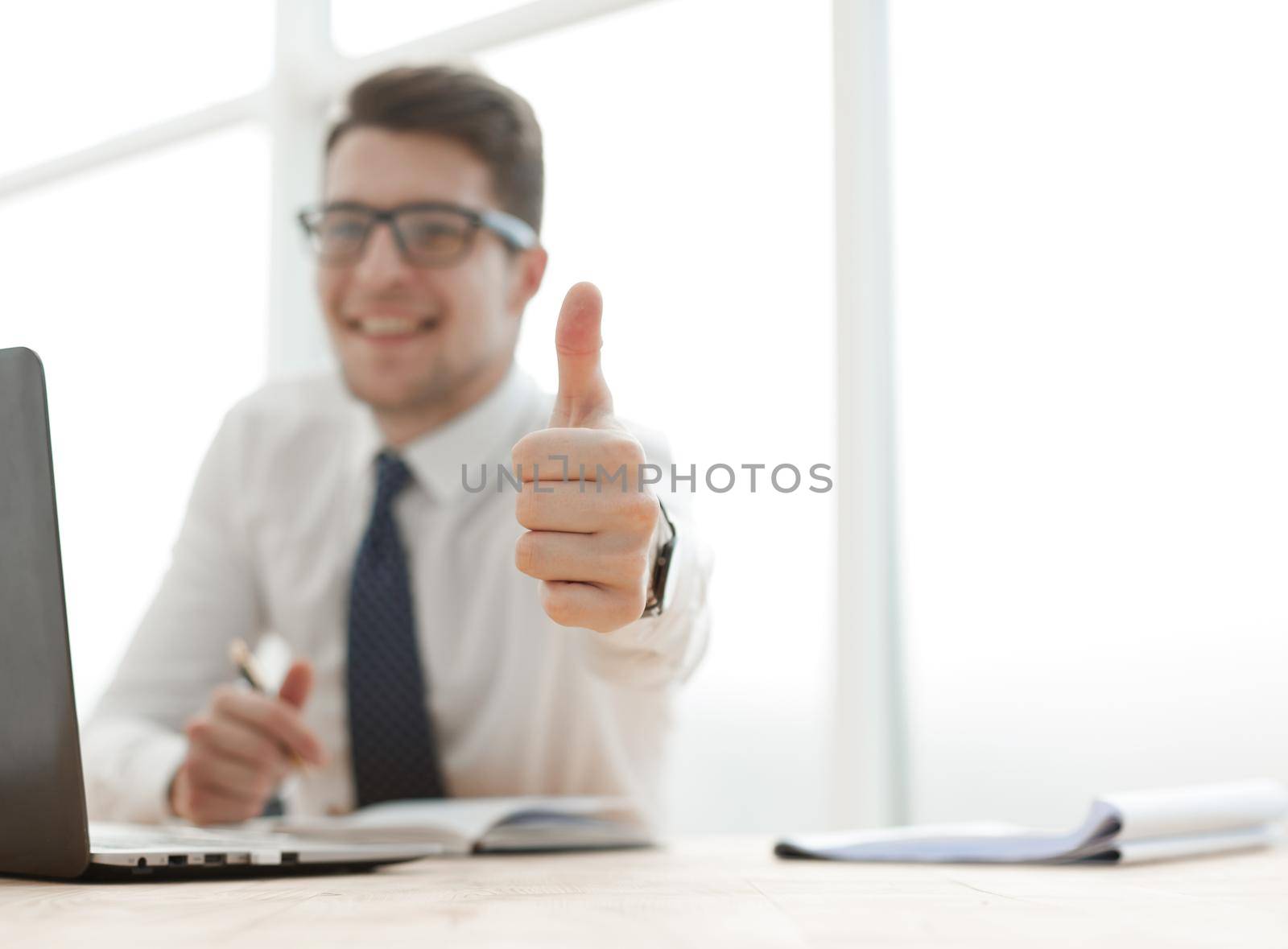 side view of a business man working on laptop and making the ok gesture by Prosto