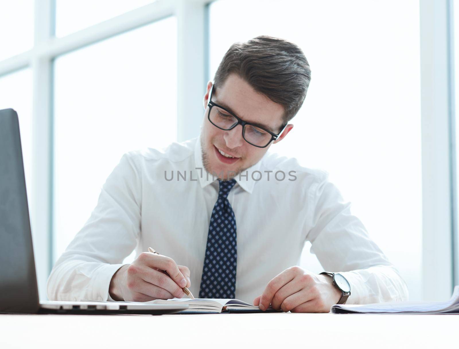 Closeup of business man writing form on clipboard.