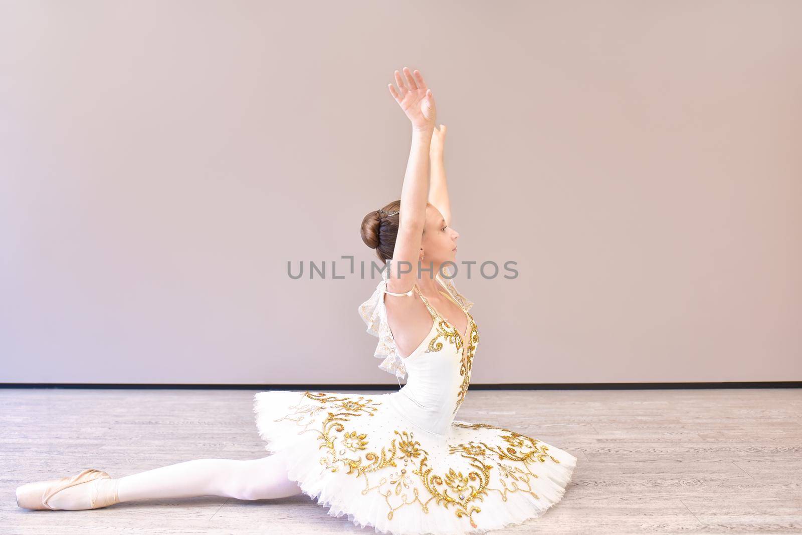 attractive young ballerina acting out. beautiful ballerina sitting forward split