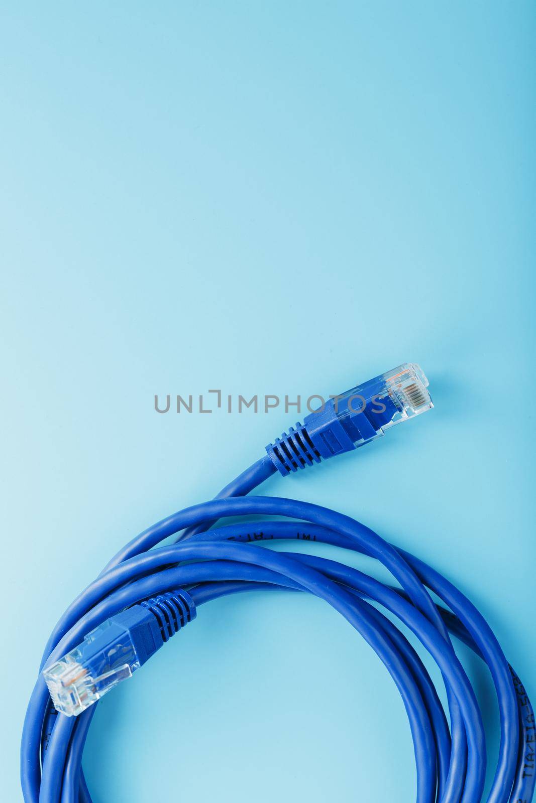 A coil of an Internet network cable for data transmission on a blue background by AlexGrec
