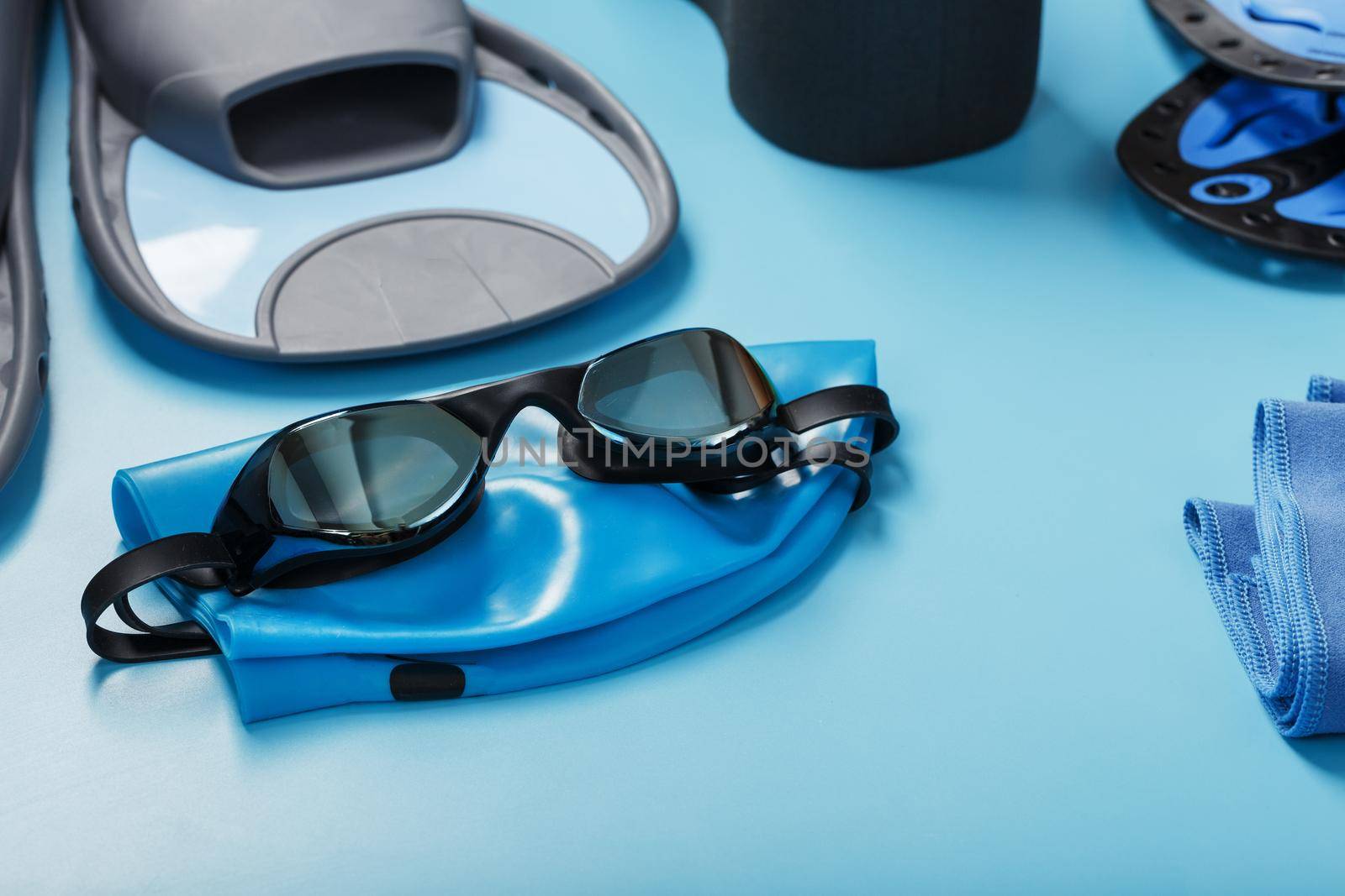 Sports equipment for swimming in the pool and open water on a blue background, close-up