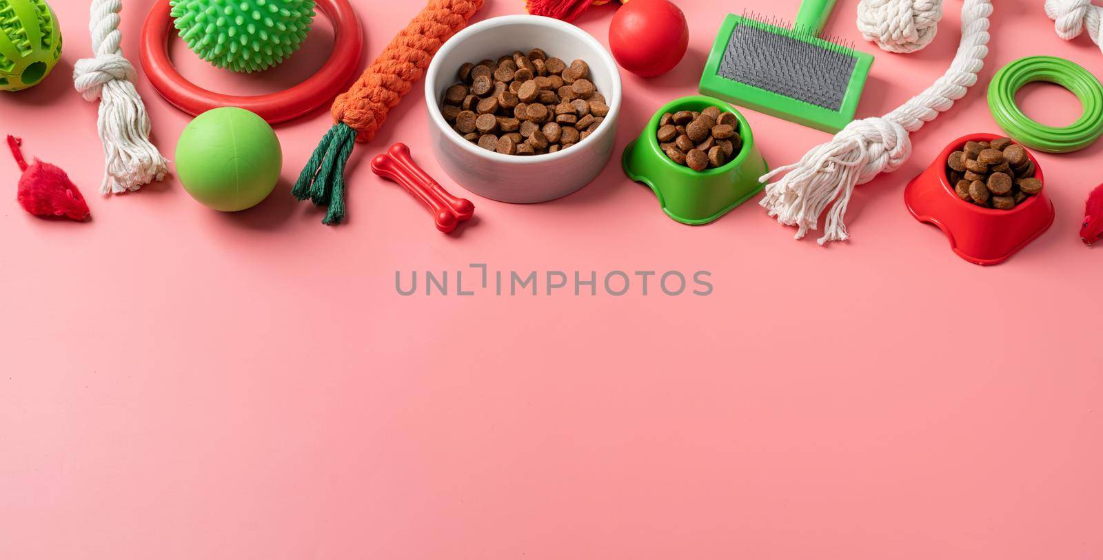 Pet care concept, various pet accessories and tools, toys, balls, brushes on pink background, flat lay