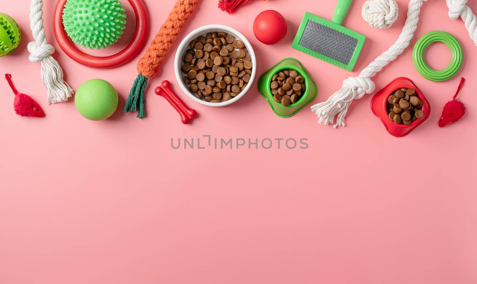 Pet care concept, various pet accessories and tools, toys, balls, brushes on pink background, flat lay