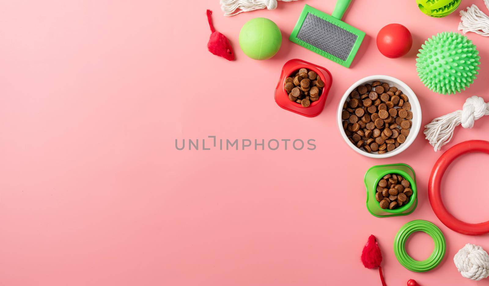 Pet care concept, various pet accessories and tools, toys, balls, brushes on pink background, flat lay