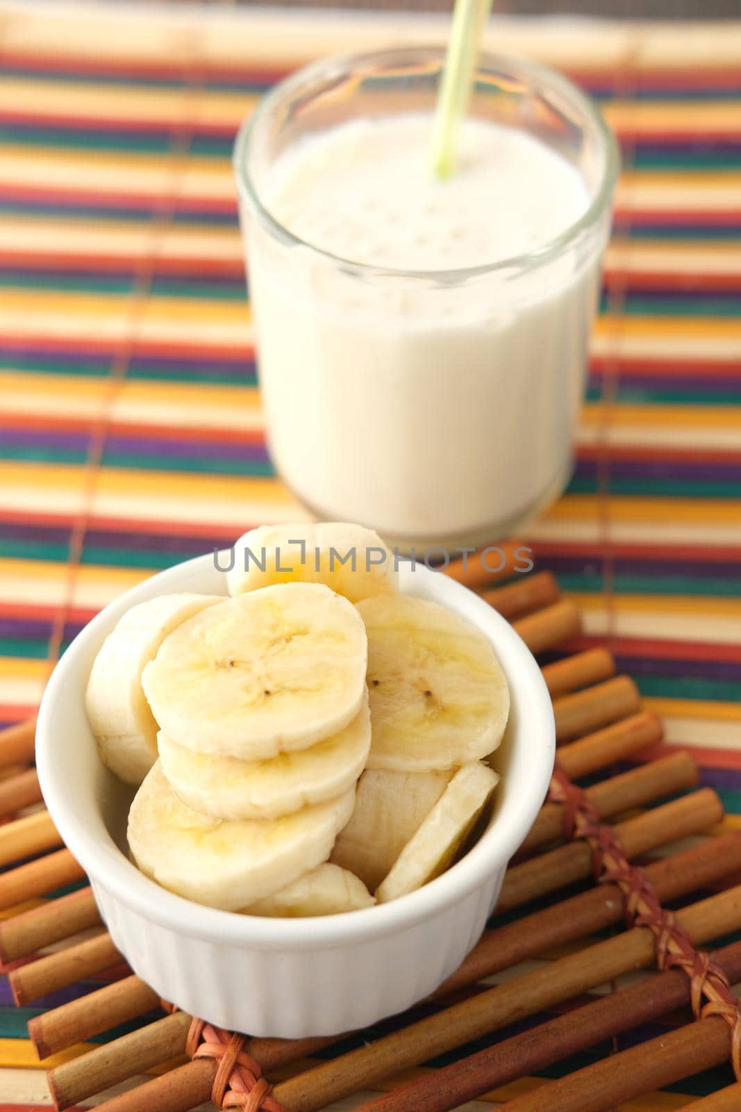 glass of milk and banana on table at morning .