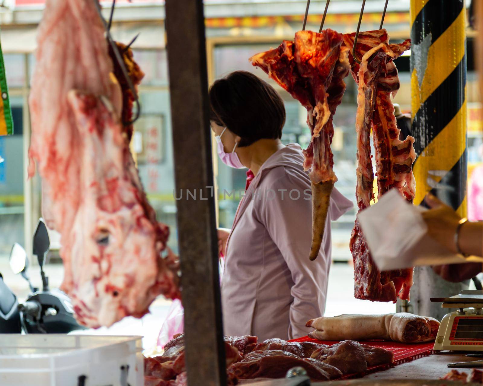 Fresh meat hanging at meat vendor in a Taipei market by imagesbykenny