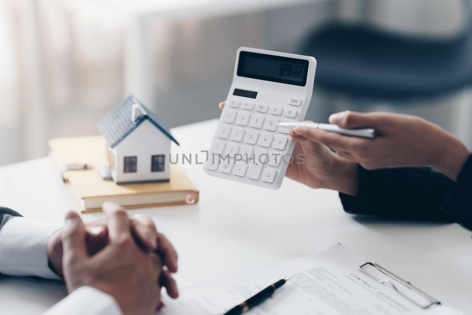 Close up Business woman or Real Estate agent explain price before signing agreement for buying house. Bank manager and real estate concept