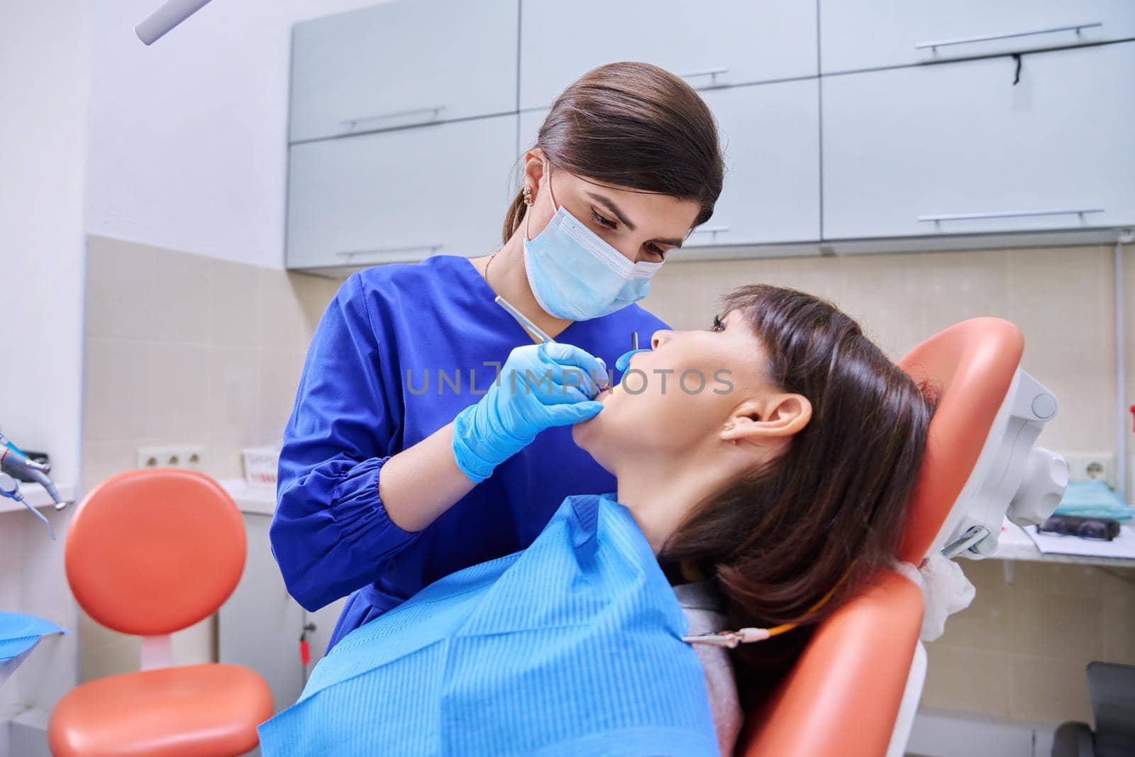 Dental treatment in clinic, woman patient in dental chair, dentist doctor using tools and equipment. Treatment, dentistry, health, teeth care concept