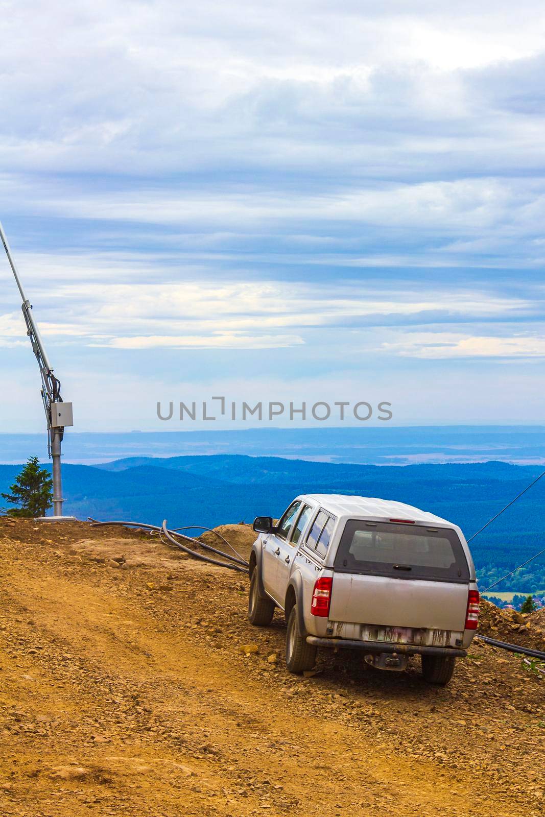 A car with the beautiful panorama view to Wurmberg mountain landscape and gondola cable car railway of Braunlage Harz Goslar in Lower Saxony Germany.