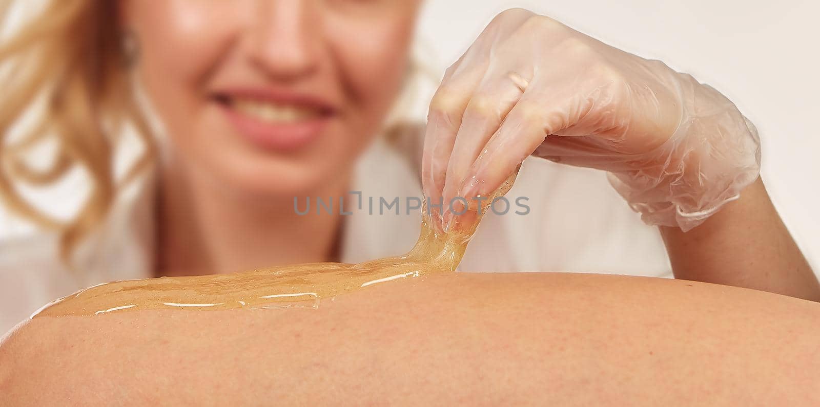 Sugar paste for light depilation. Depilation with sugar paste in the salon on a white background.