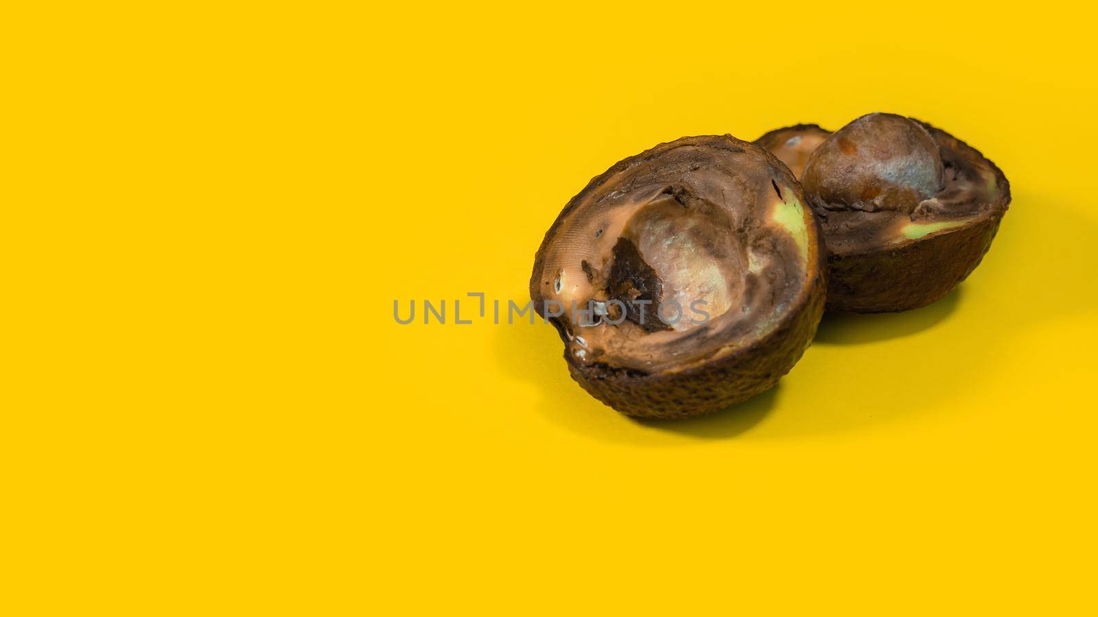 Ugly food on yellow background, bad avocado. by RecCameraStock