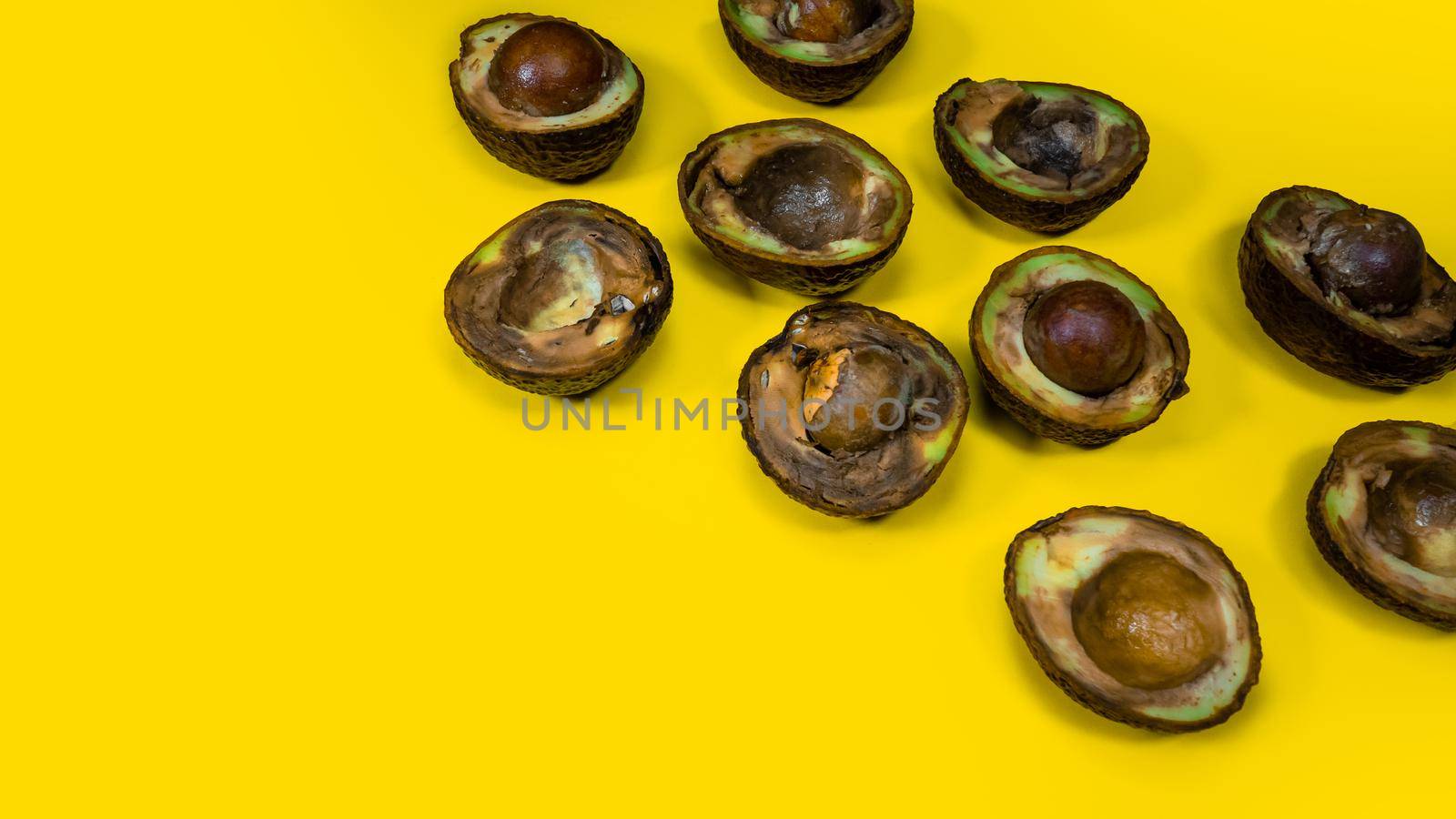 Creative Composition many Bad Avocado on yellow background. Unhelthy Food Concept. by RecCameraStock