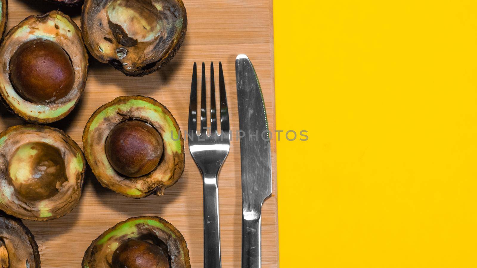 Bad Avocado Halfs on Yellow background. Bad Vegan food. by RecCameraStock