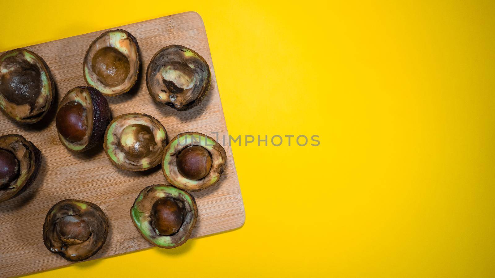 sliced unhealthy rotten avocados on old gray table