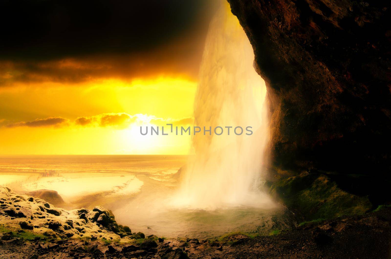 Photo of Seljalandsfoss Waterfall on the South Coast of Iceland bathed in the otherworldly light of the midnight sun with selective focus on the water