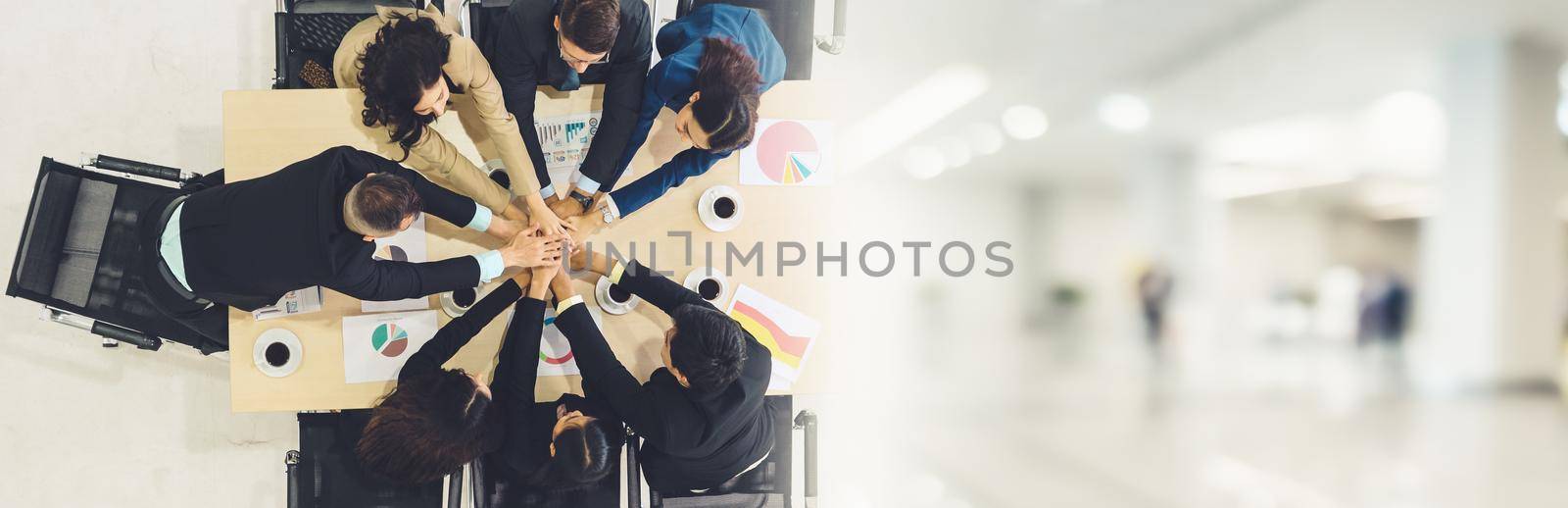 Happy business people celebrate teamwork success together with joy at office table shot from top view . Young businessman and businesswoman workers express cheerful victory in broaden view .