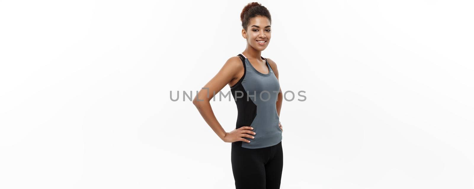 Healthy and Fitness concept - Beautiful American African lady in fitness clothes ready for workout. Isolated on white background