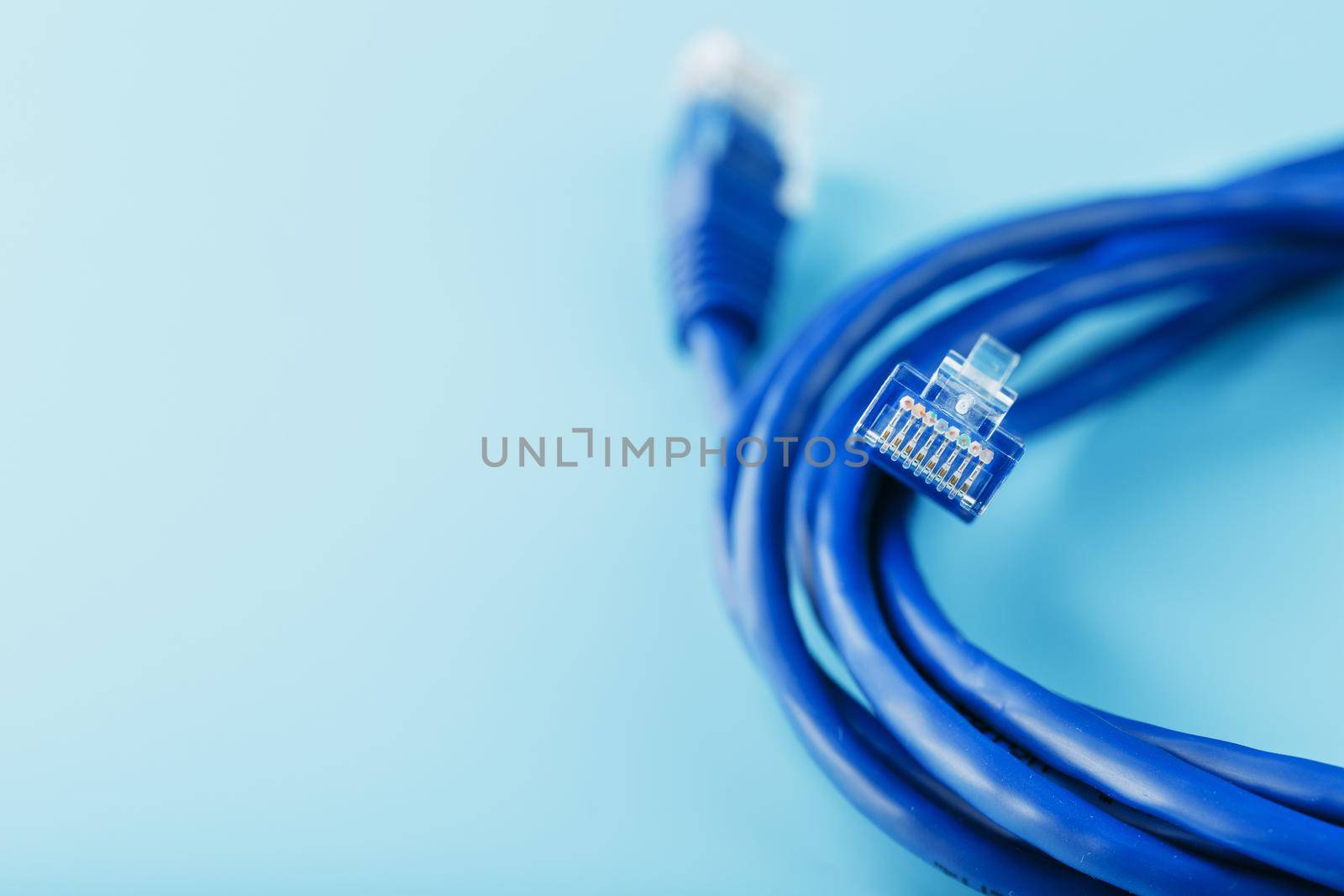 Blue UTP Internet Cable Isolated on a blue background Ethernet Cord by AlexGrec