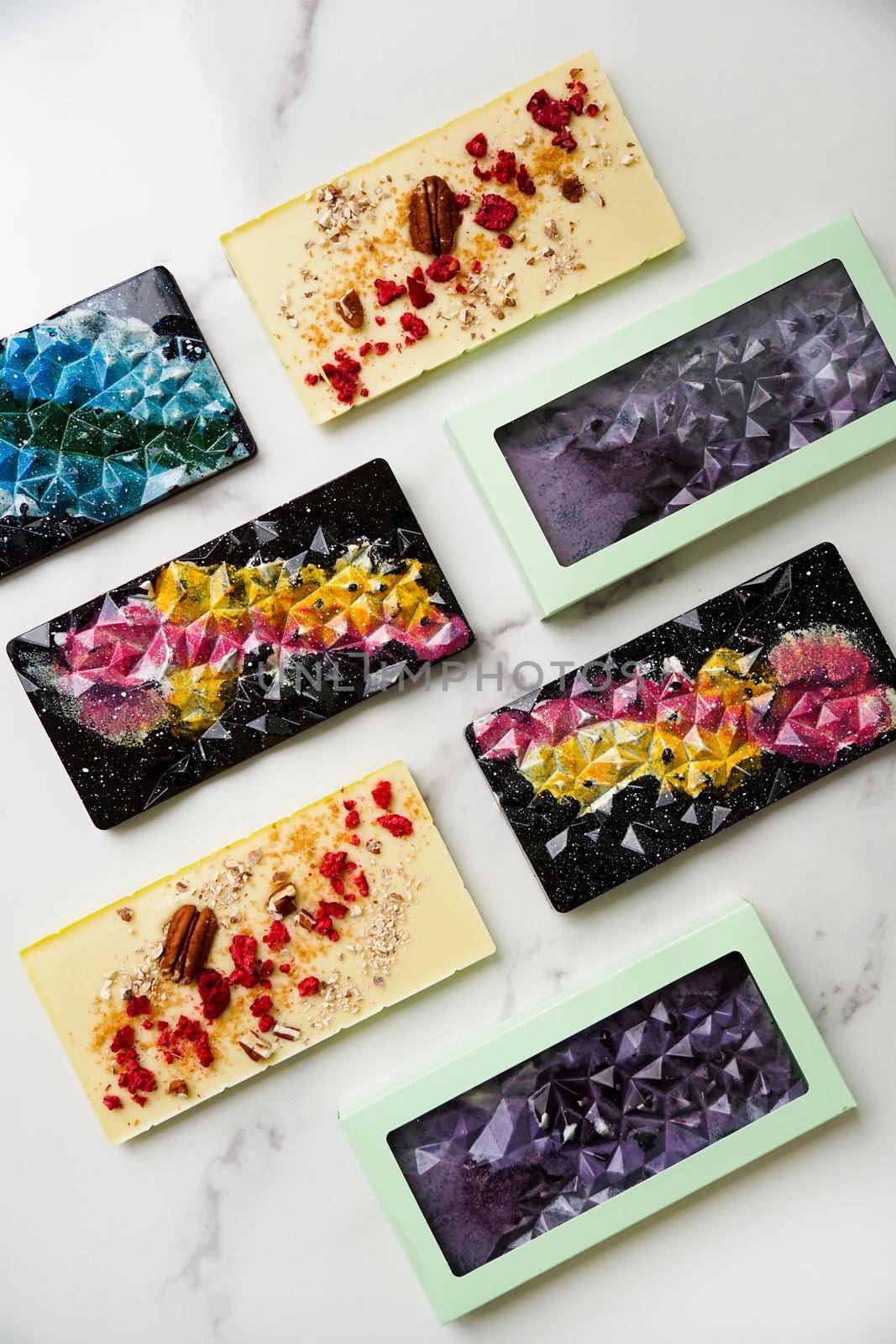 Hand-made bars of colorful chocolate on a light marble background by natali_brill