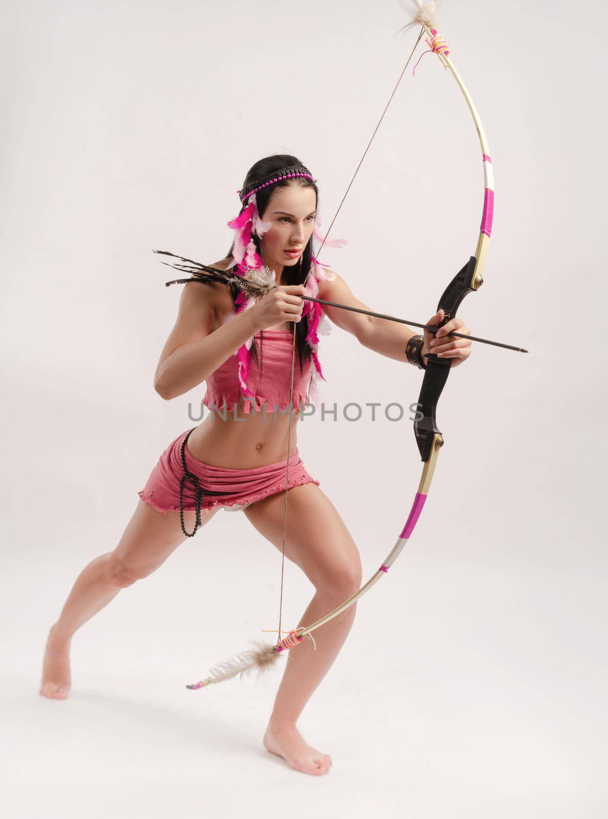 the slender woman in an Amazon costume with a bow and arrow in her hands